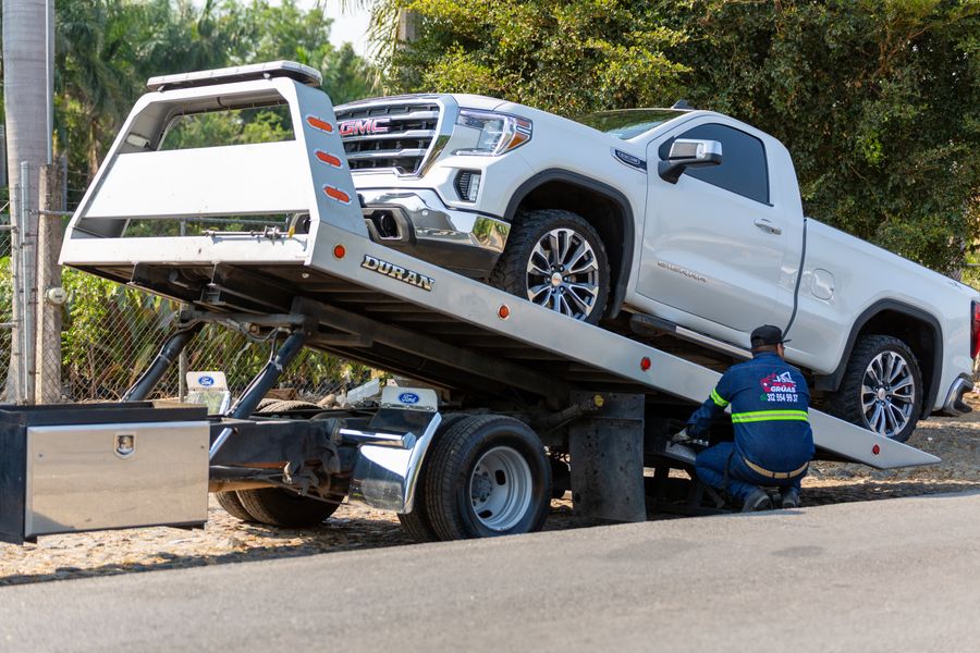 A vehicle being winched onto a transporter